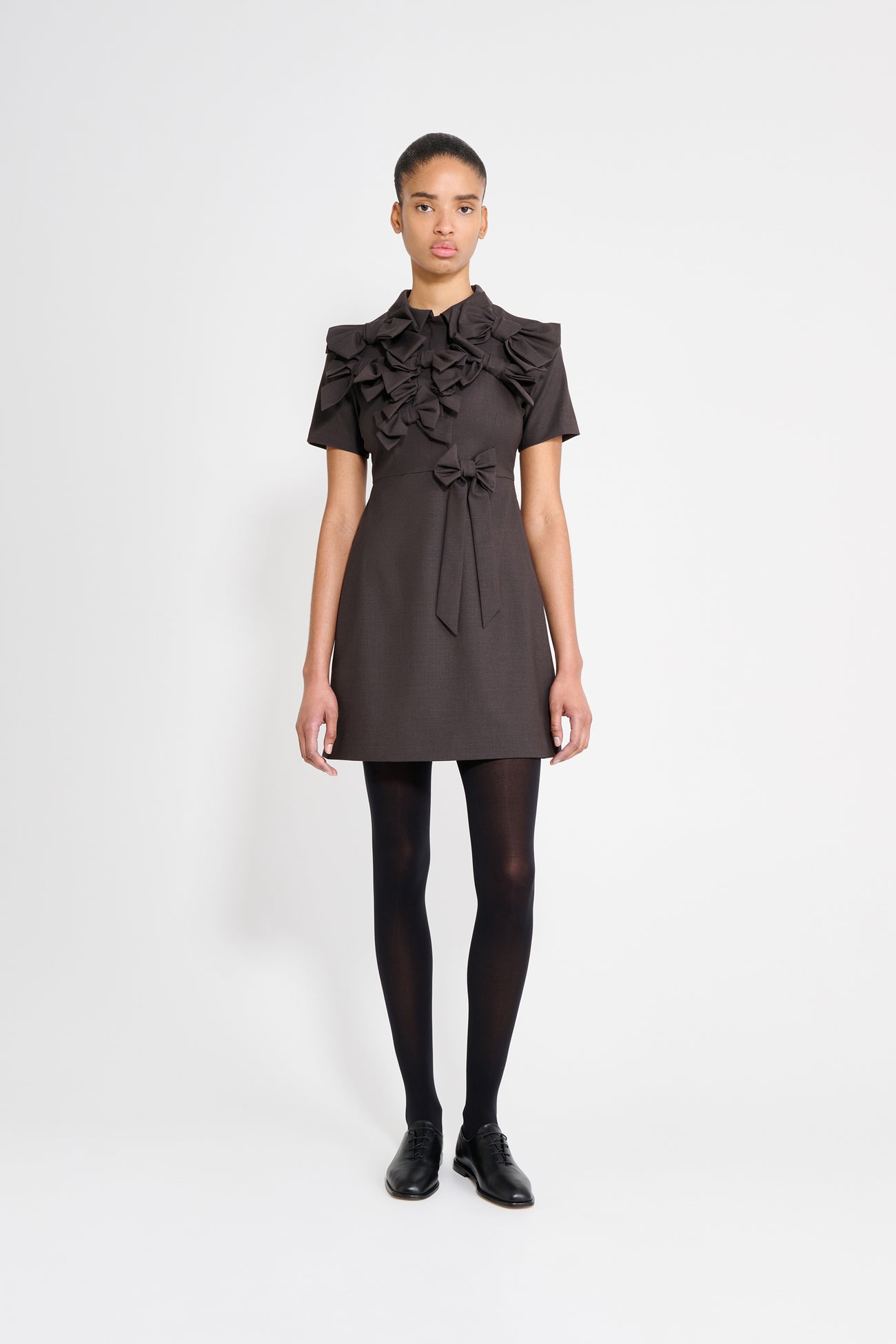 The wool dress features the seasonal bow bouquet technique, where timeless elegance meets refined craftsmanship in a seamless fusion of sophistication and grace