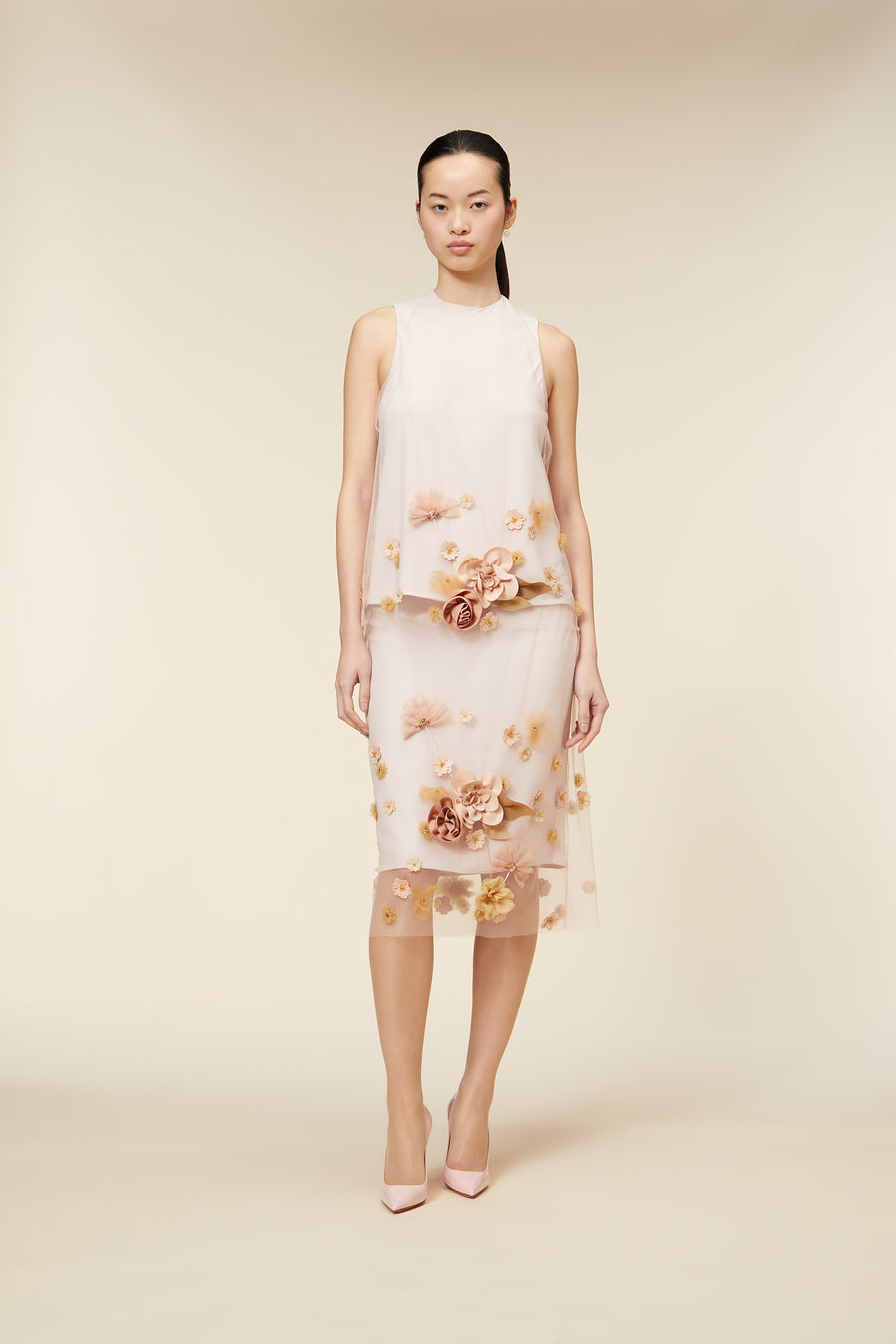 Elegant dress featuring pale pink tulle with intricate floral embroidery, accentuated by delicate three-dimensional appliqués.