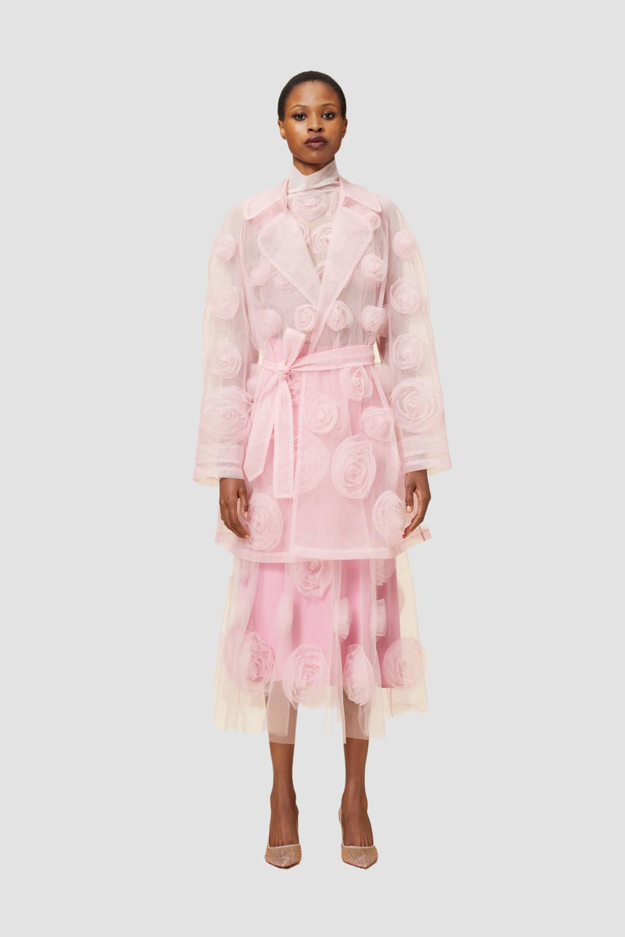 Pink sheer organza trench coat with delicate 3D floral appliqués, layered over a matching pink dress.