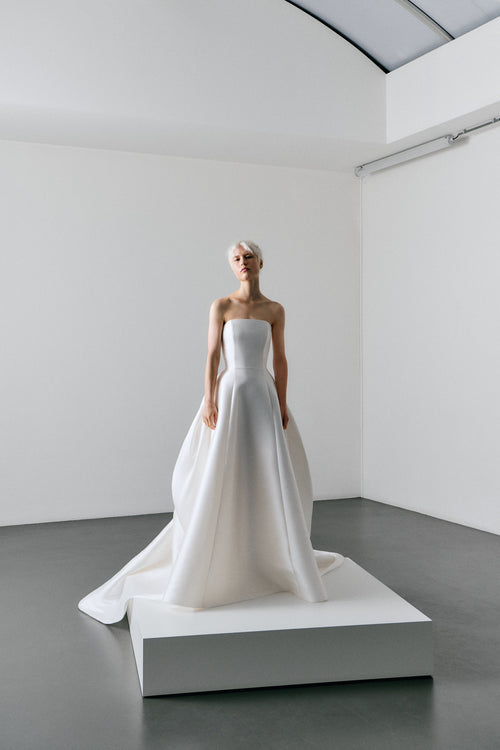 White wedding dress on a mannequin in a minimalistic room.