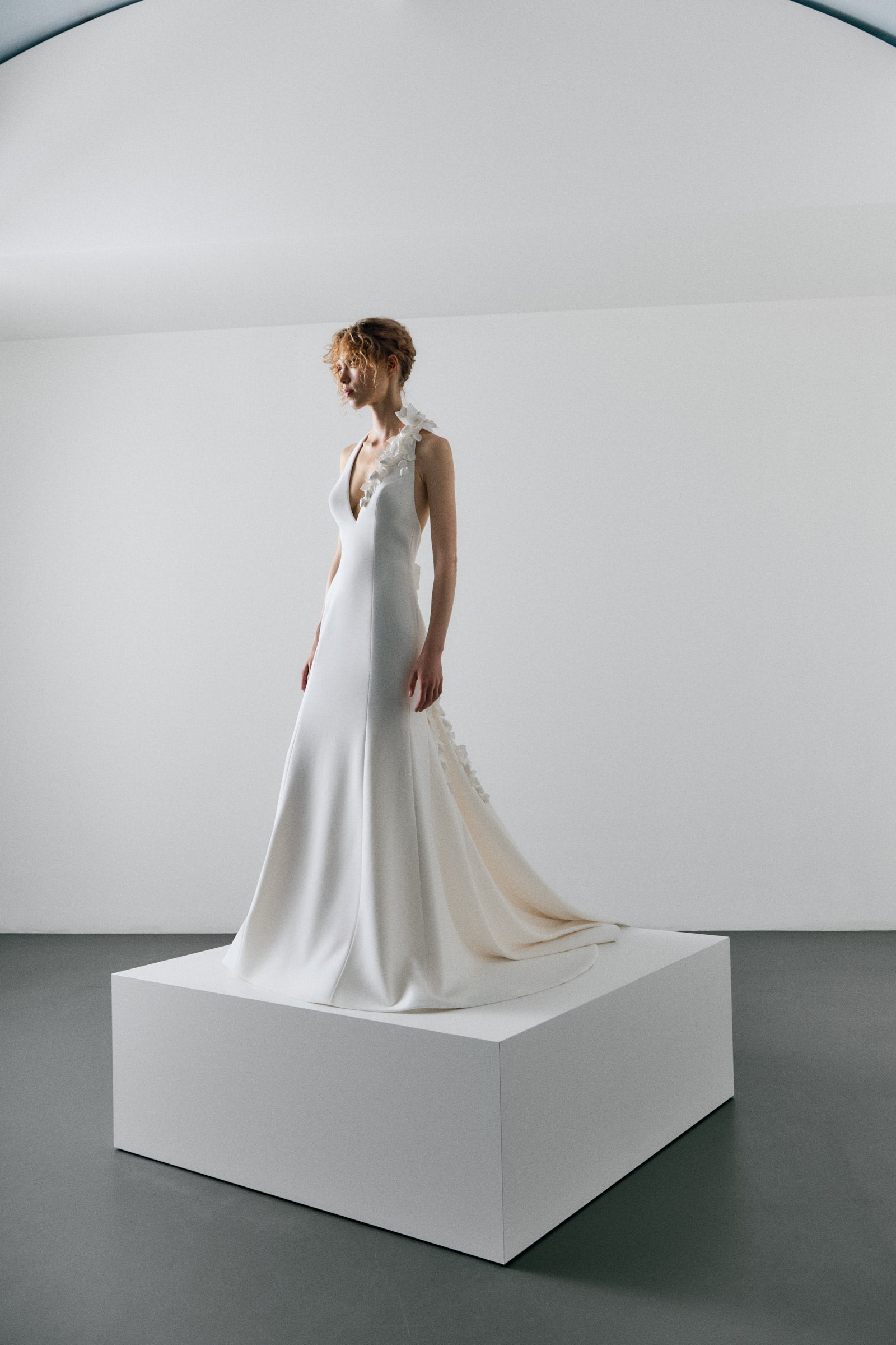 White wedding dress on a mannequin against a plain white background