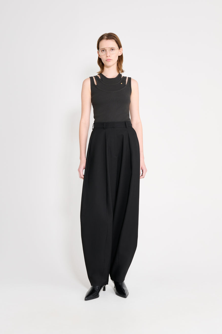 Model wearing black top and black balloon trousers.