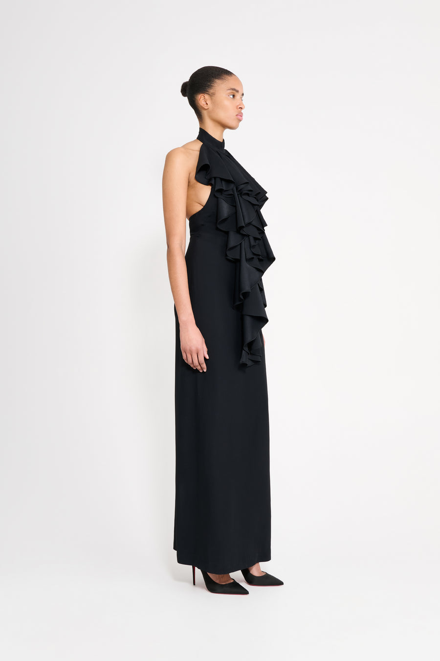 Woman wearing a black one-shoulder ruffled gown on a white background