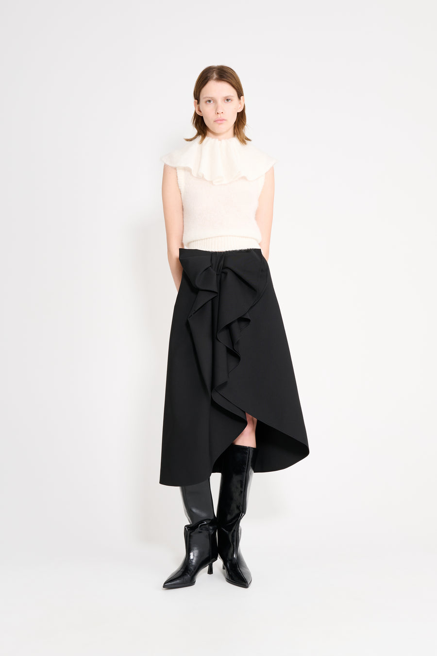 Model wearing a white volant neck top.