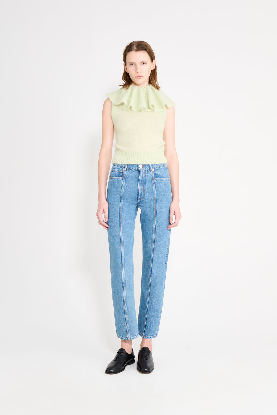Model wearing a mint volant neck knit top.