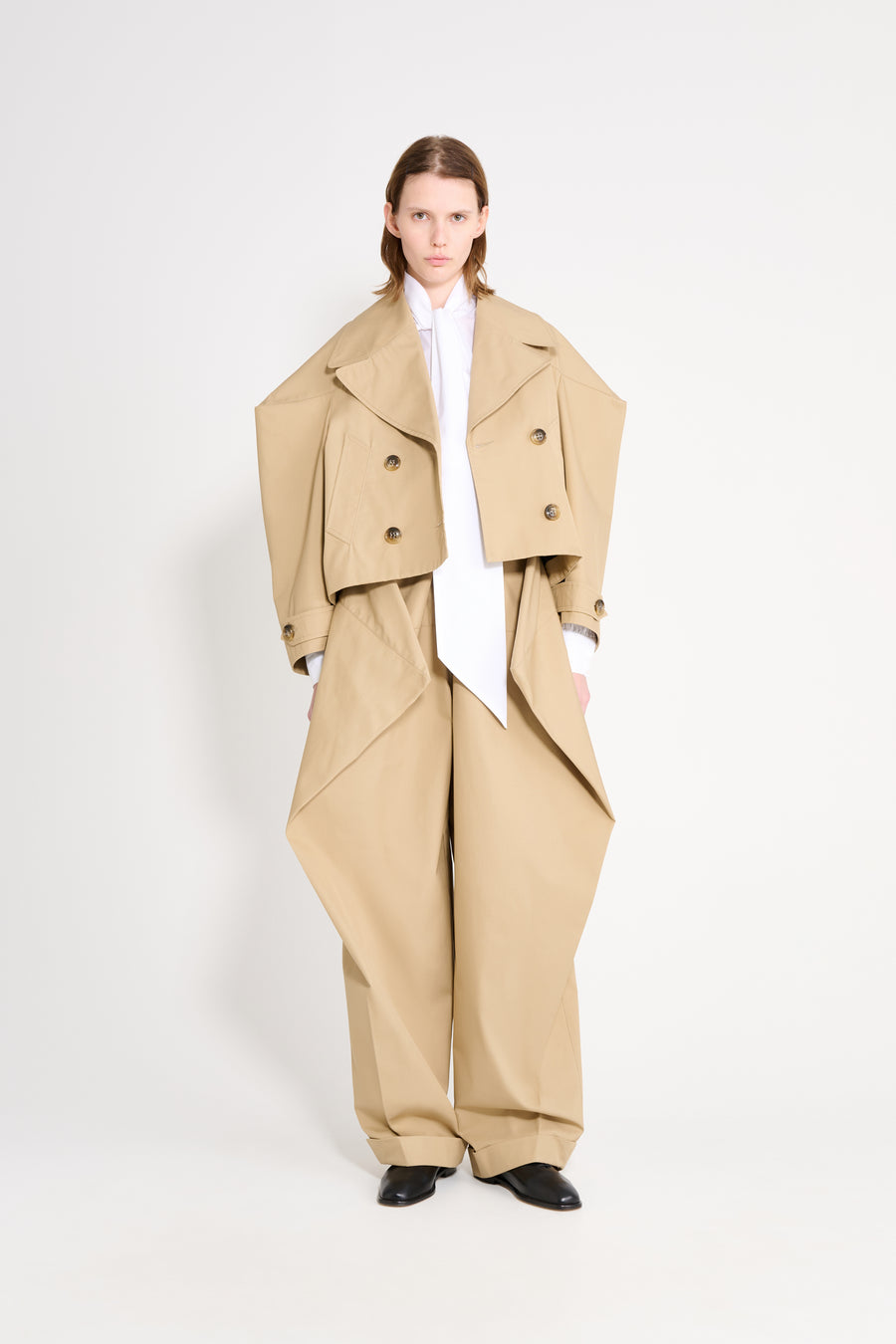 Person wearing a beige outfit with a white background