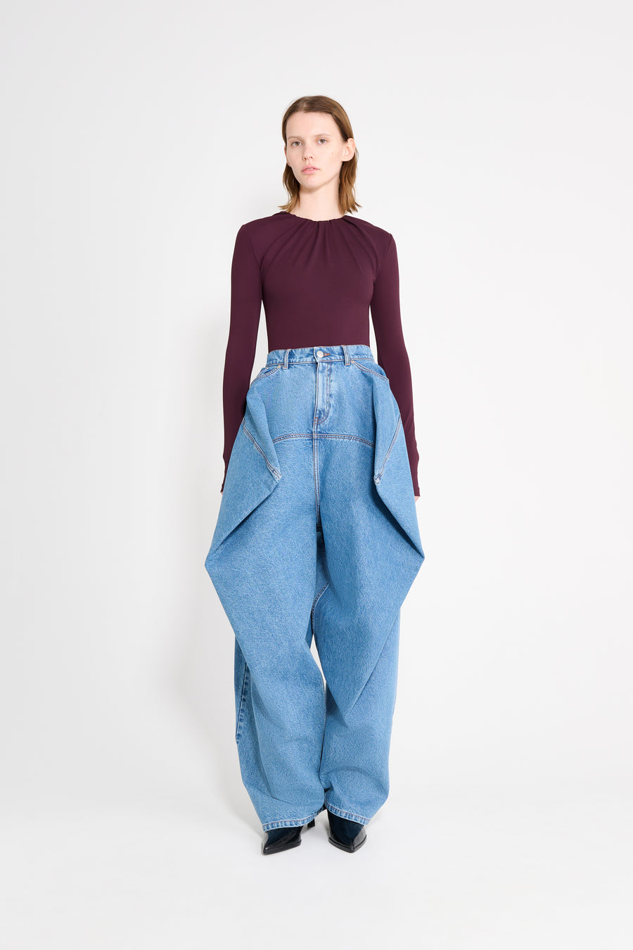 Model wearing a drape body with jeans.
