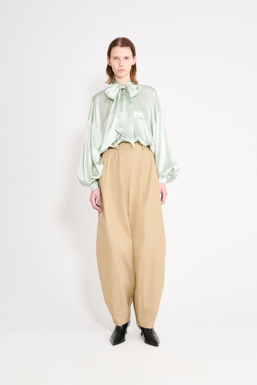 Model wearing a mint satin shirt. 