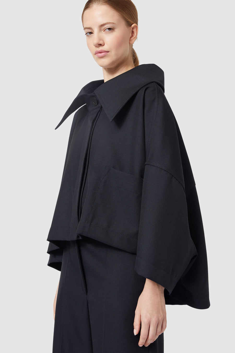 Woman wearing a stylish black wool jacket with wide collar, perfect for a chic and elegant fashion statement.