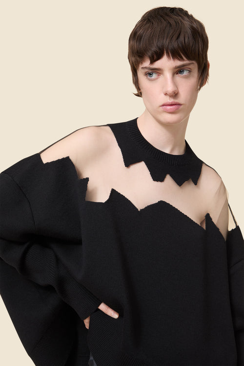 The knitwear, inspired by viktor&rolf's scissorhands, is crafted with 100% merino wool and showcases intricate holes knitted with transparent yarn in a jacquard technique