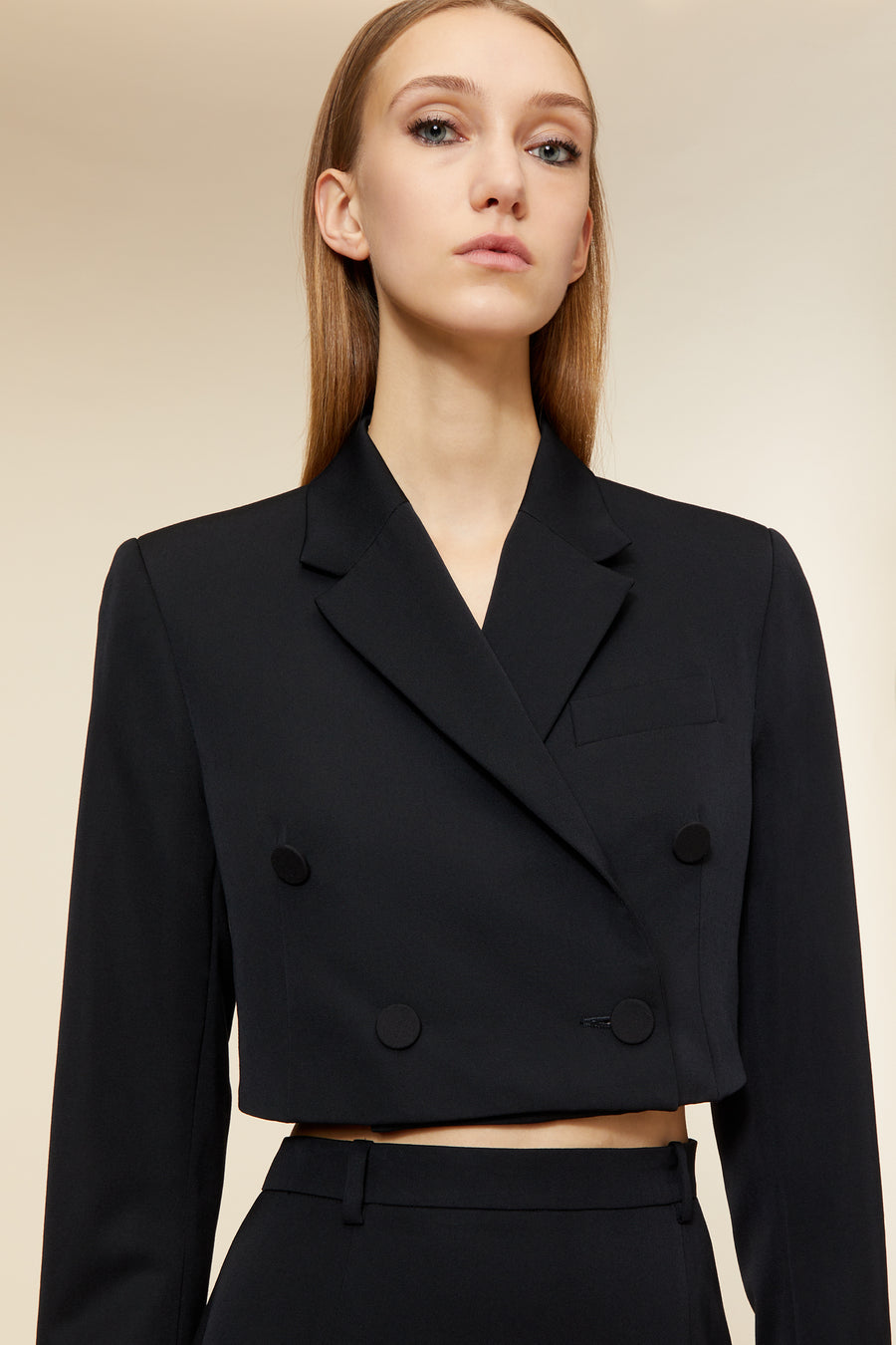 Elegant cropped black double-breasted blazer with sleek button detailing, tailored for a modern and sophisticated look.