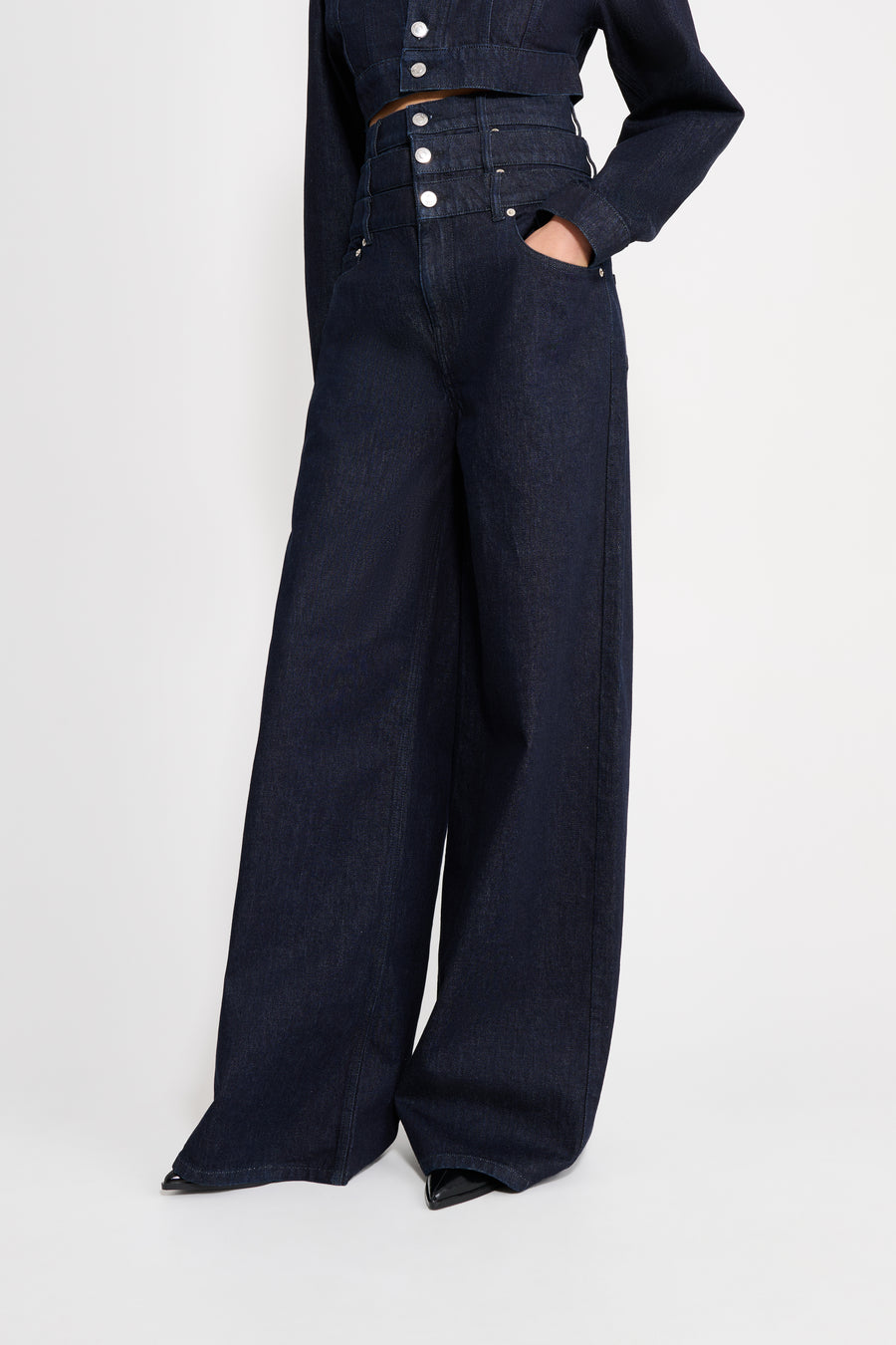 Black denim outfit with wide-leg pants and a cropped jacket on a white background