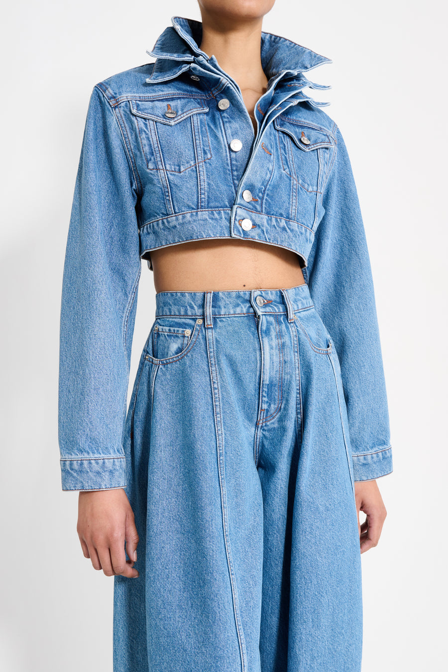 Person wearing a matching denim jacket and skirt on a white background