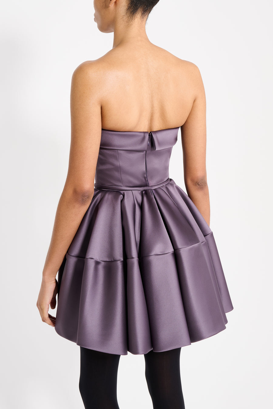 Model wearing a purple mini dress on a white background.