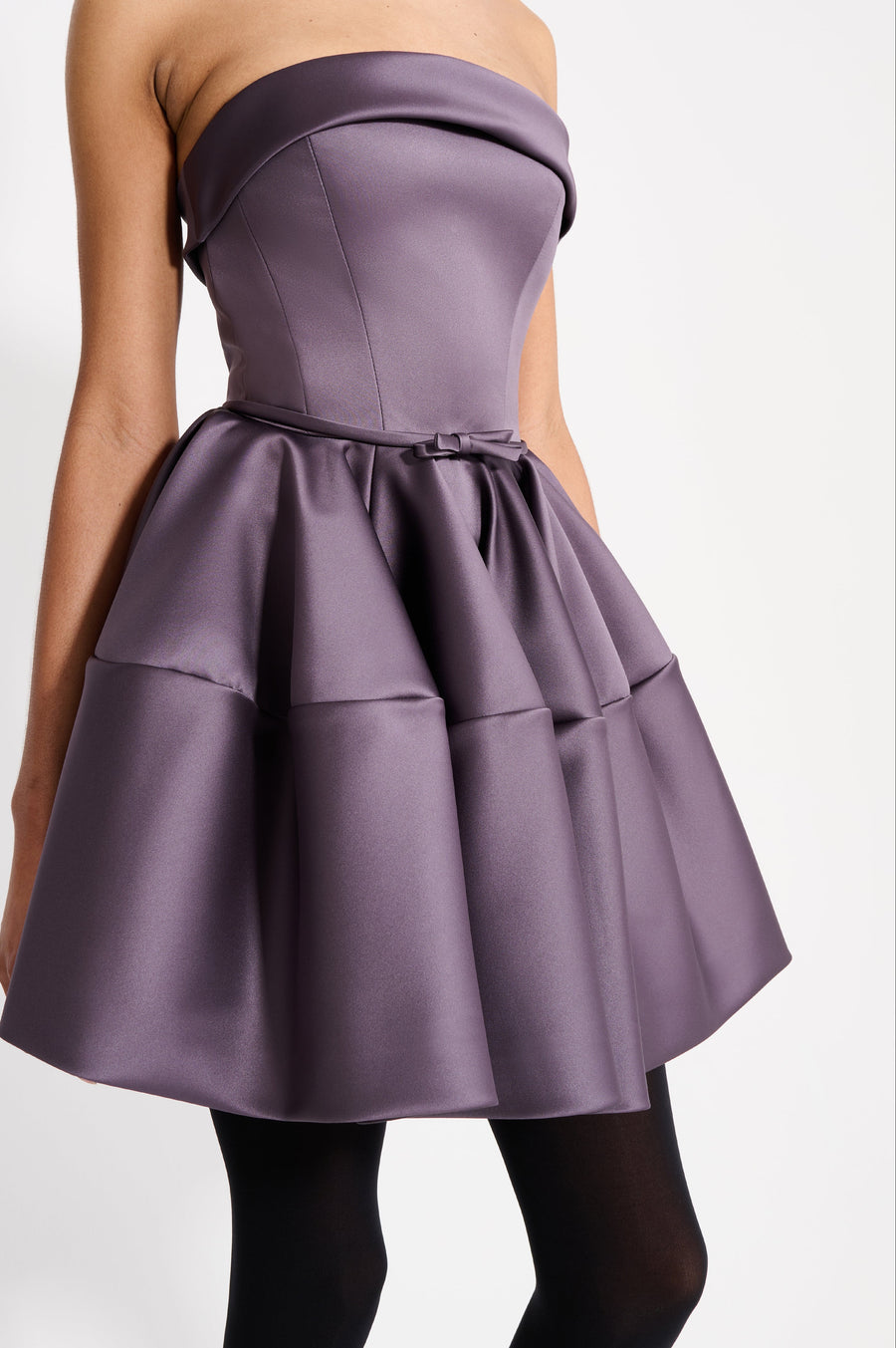 Model wearing a purple mini dress on a white background.