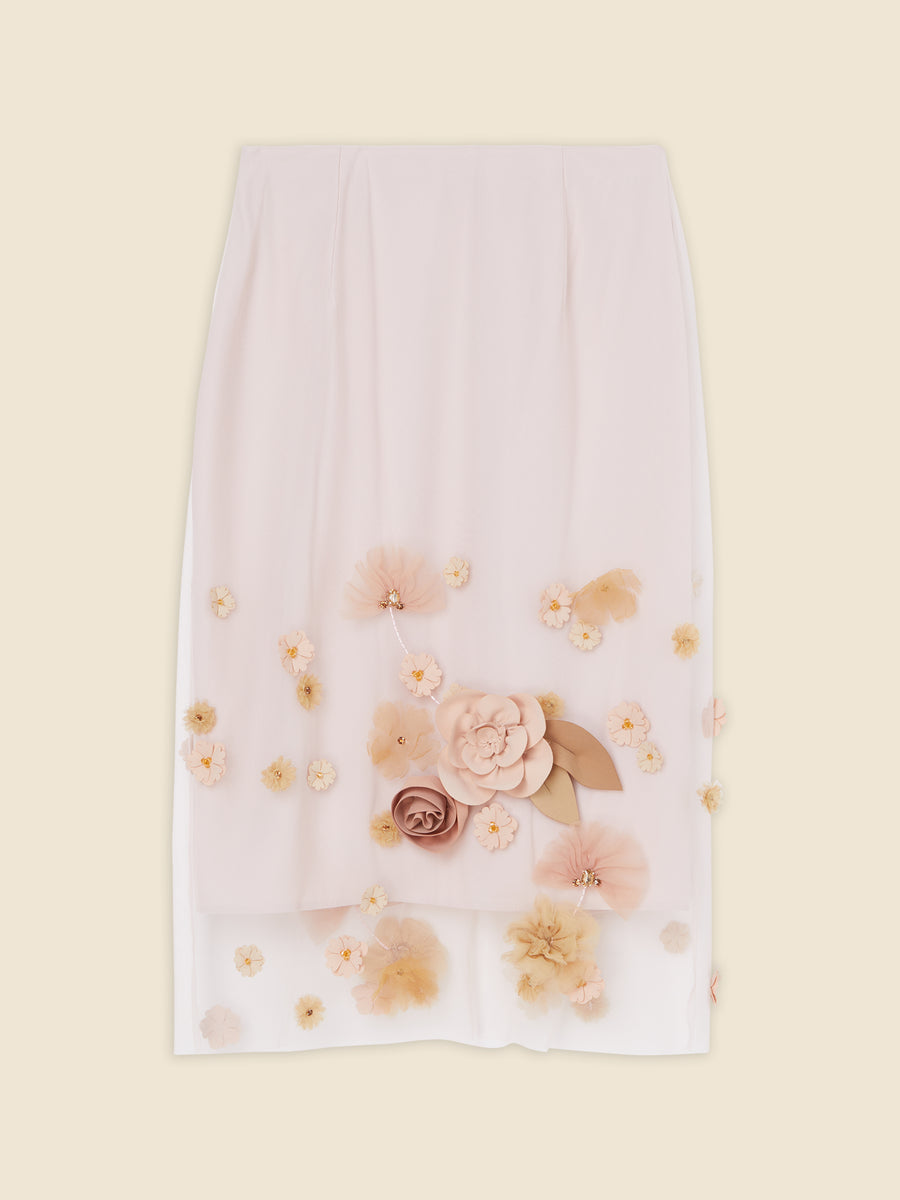 Elegant ivory skirt adorned with layered fabric flowers in peach tones, featuring intricate floral appliqué details.