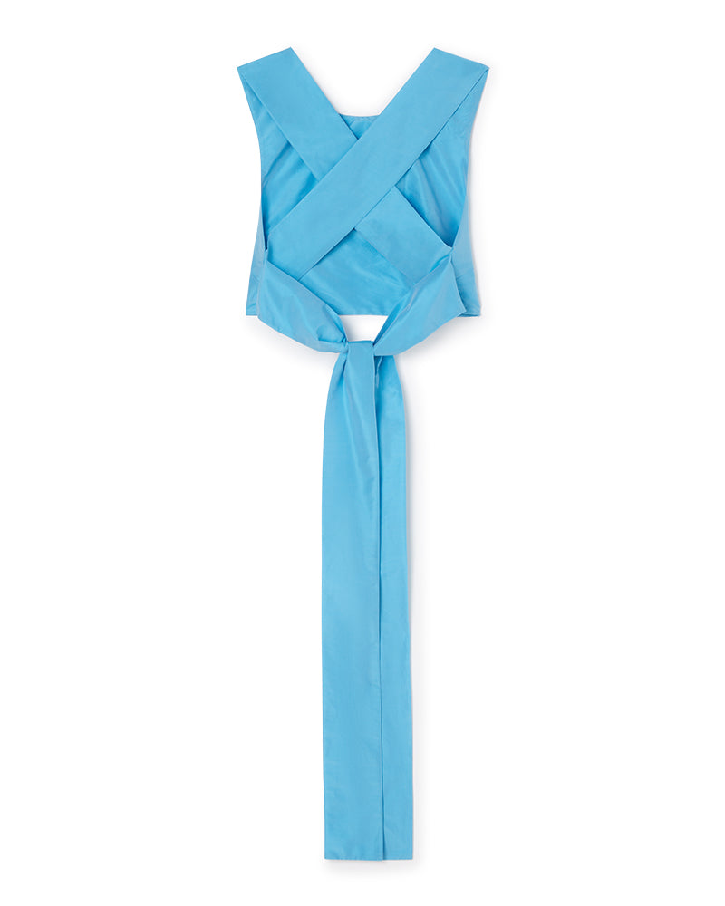 Cross-back top in vibrant sky blue fabric, featuring wide shoulder straps and a long tie detail at the back for a stylish finish.
