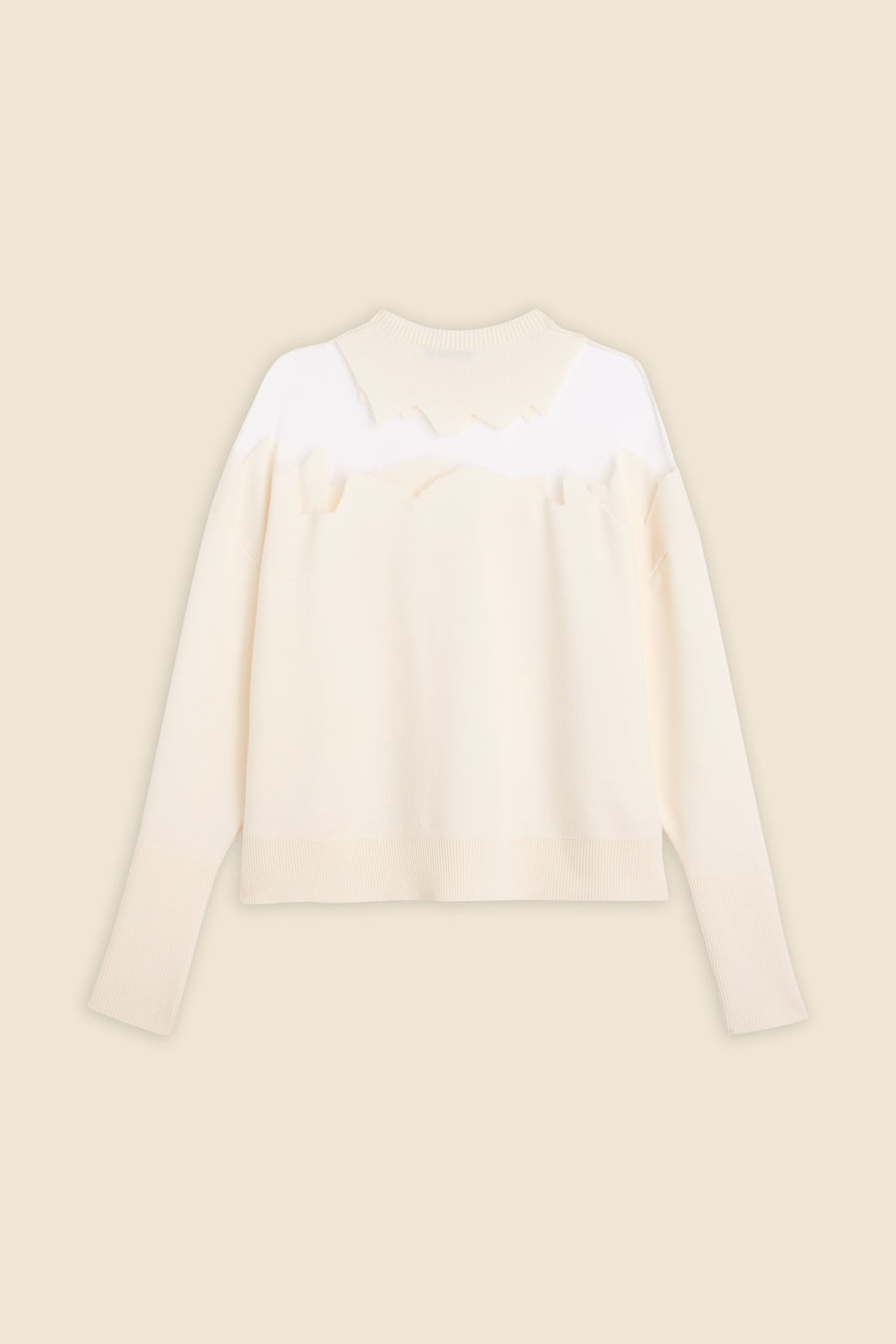 Cream-colored sweater with a ribbed hem and collar, featuring a unique, jagged white design across the shoulders.