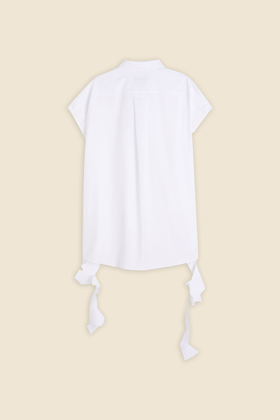 Back view of a white short-sleeve cotton blouse with decorative ribbon accents against a beige background.
