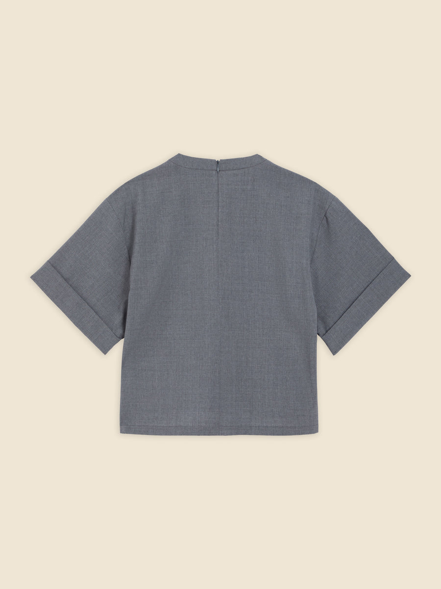 Elegant short-sleeve blouse in textured gray fabric featuring a subtle back zipper and minimalist design.