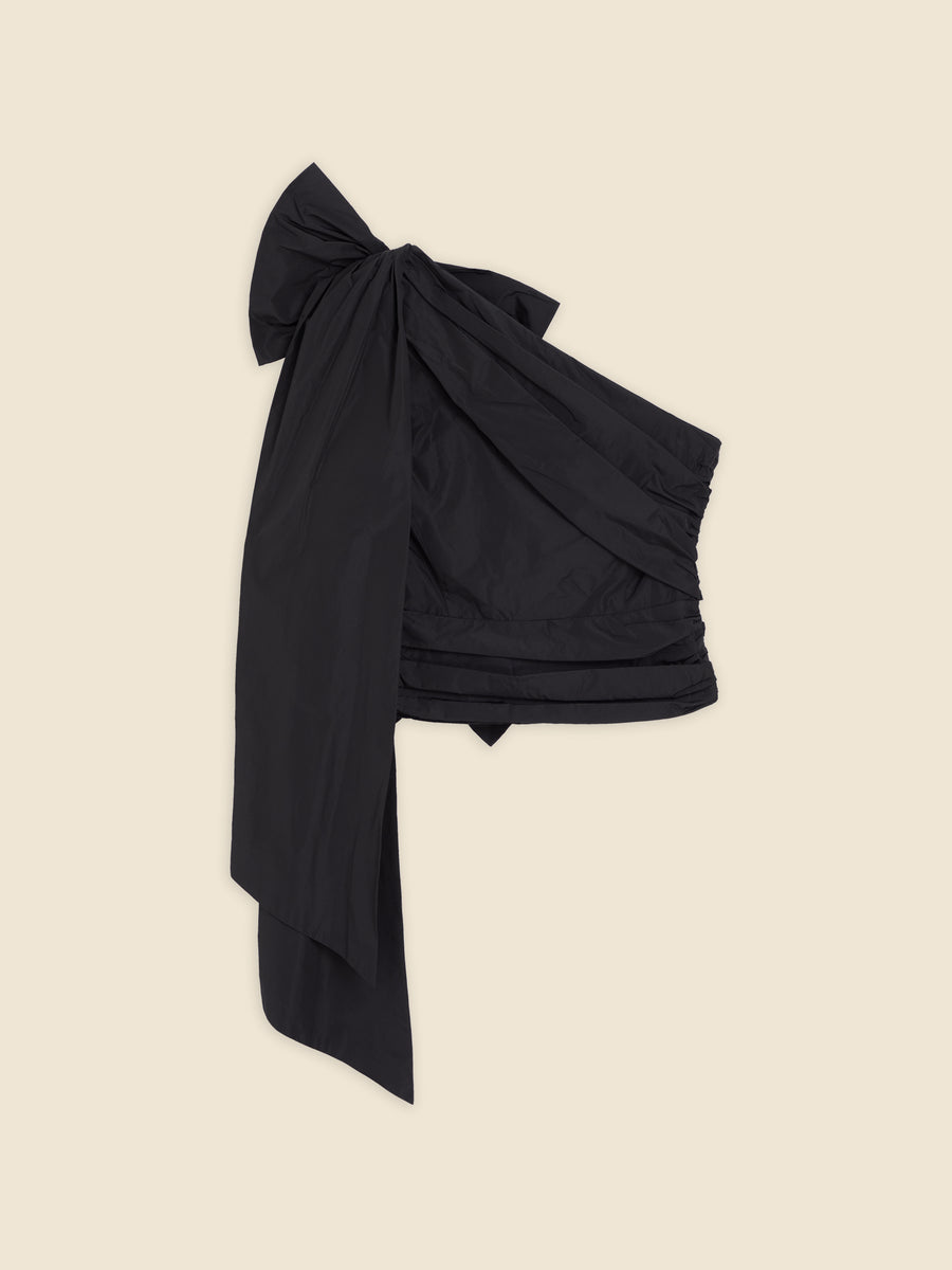 Black satin mini skirt with oversized bow detail, featuring ruching on the side for a sculpted silhouette and elegant finish.