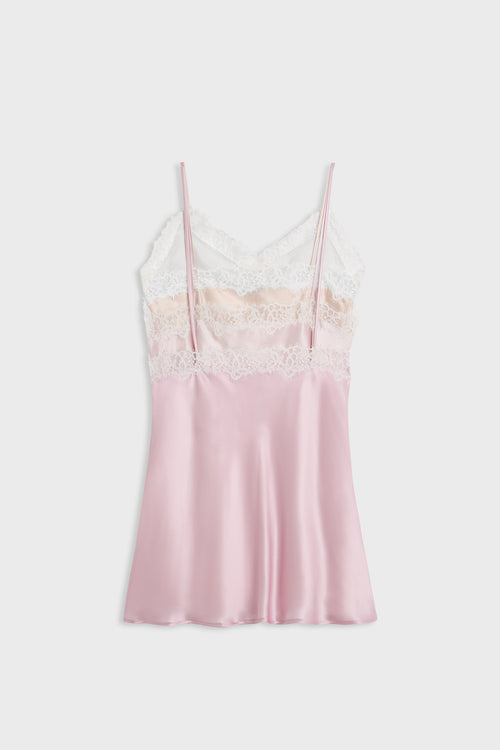 A light pink satin slip dress with thin straps, a white lace bodice, and a beige lace band, displayed against a light gray background.