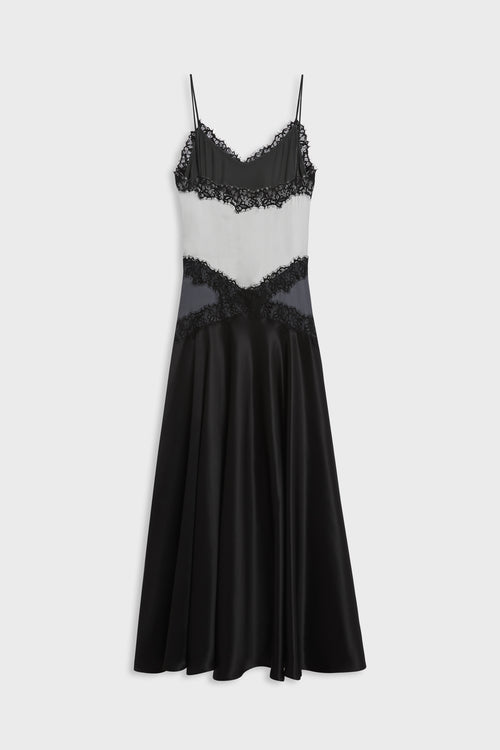 A black and white color-blocked midi slip dress with black lace trim and thin spaghetti straps, shown against a light gray background.