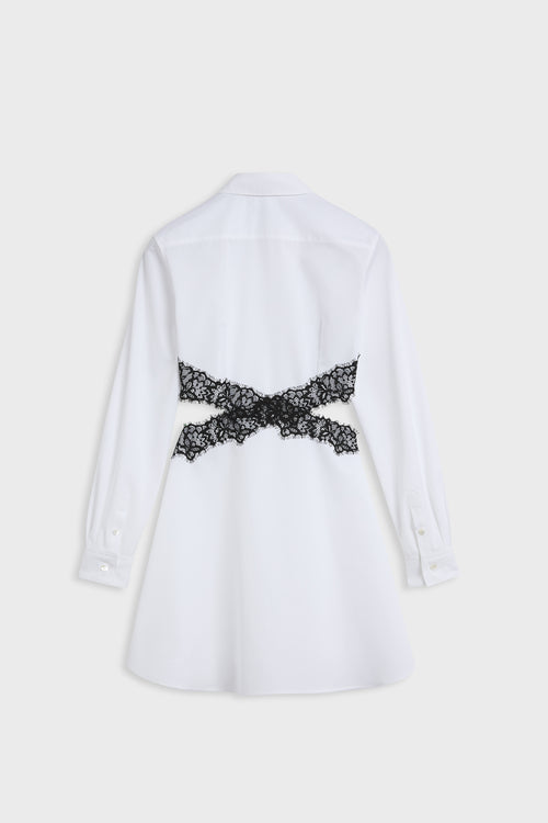 A white long-sleeve shirt shown from the back, featuring a decorative black lace bow tied across the upper back.