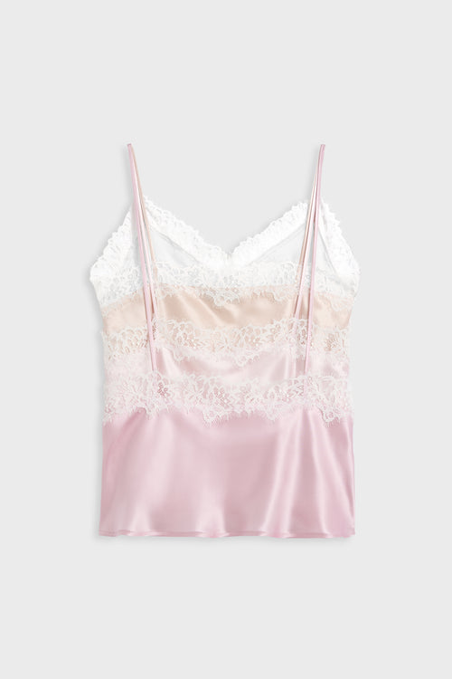 A satin camisole top with a color-blocked design in white, pale pink, and light peach, featuring white lace trim and thin spaghetti straps, shown against a light gray background.