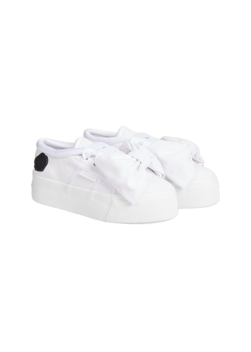 White sneakers with oversized bow detailing, featuring a chunky sole and minimalistic design for a stylish casual look.