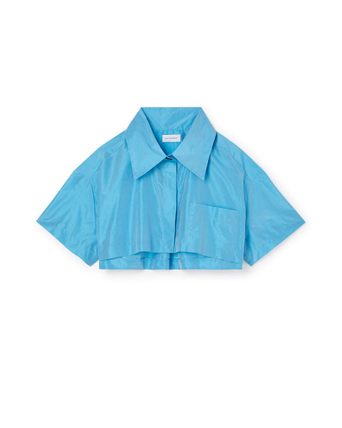 Light blue cropped short-sleeve shirt with large collar and chest pocket, featuring a smooth, shiny fabric texture.