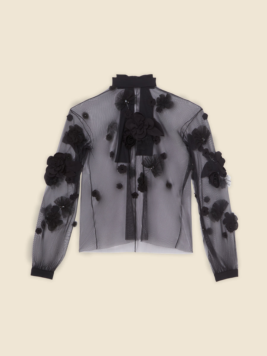 Sheer black blouse with floral appliqués, long sleeves, and high neck against a neutral background.