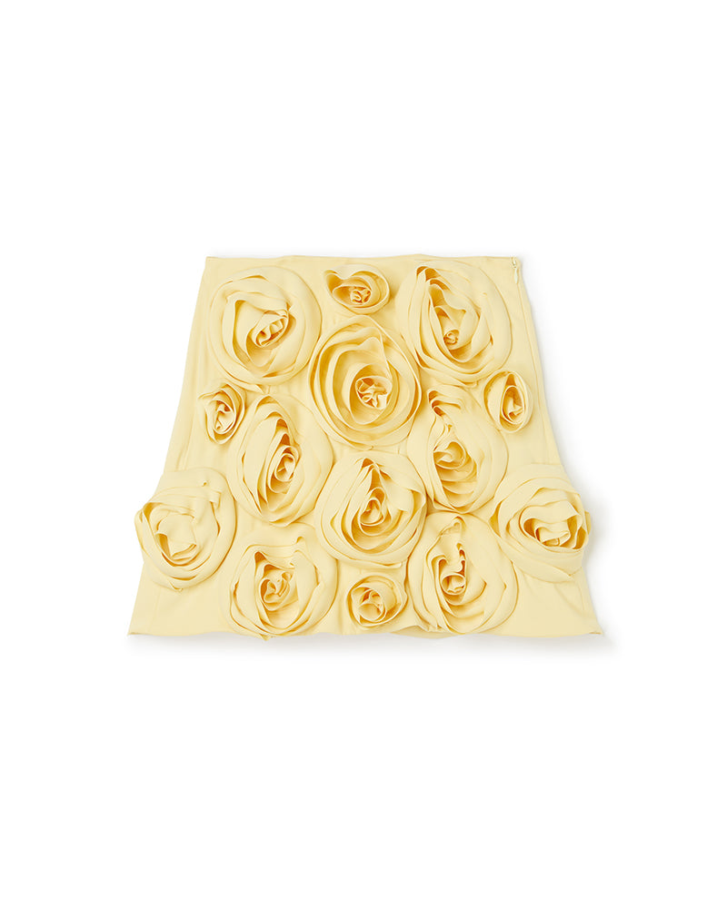 Elegant yellow skirt adorned with intricate rosette fabric detailing, showcasing a sophisticated floral design aesthetic.