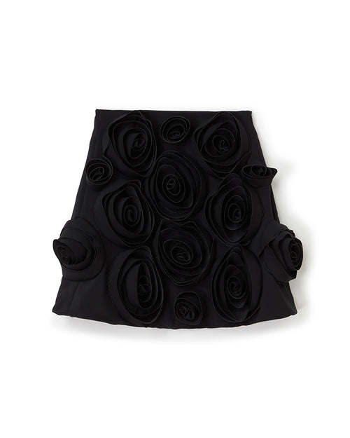 Elegant black skirt adorned with intricate 3D fabric roses, showcasing artistic design and sophisticated craftsmanship.