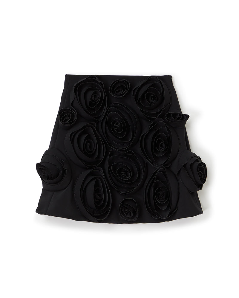 Elegant black skirt adorned with intricate 3D fabric roses, showcasing artistic design and sophisticated craftsmanship.