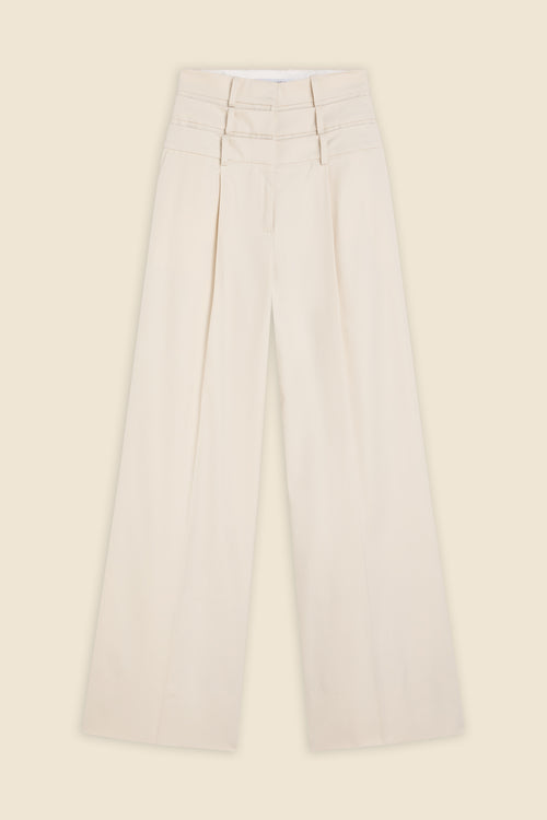 Beige multi-layer high waist trousers on a beige background.