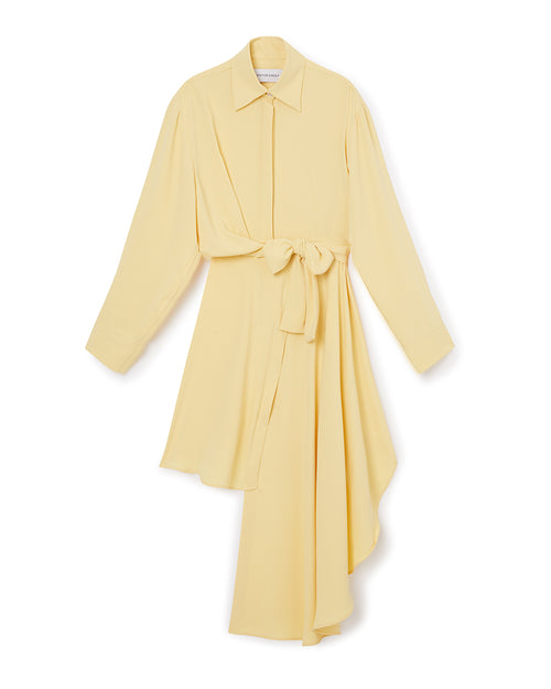 Flowing asymmetric yellow shirt dress with a waist tie, featuring a classic collar and long sleeves for a chic silhouette.