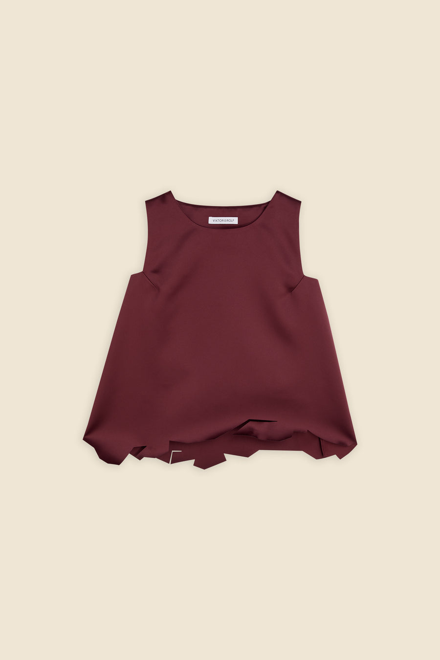 Sleeveless top in deep burgundy with a unique asymmetrical hemline, crafted in smooth fabric for a chic, modern look.