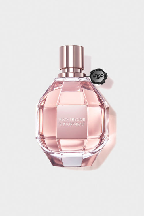 A feminine, diamond-cut glass bottle of Flowerbomb by Viktor & Rolf, featuring a blush pink fragrance for women with floral notes.
