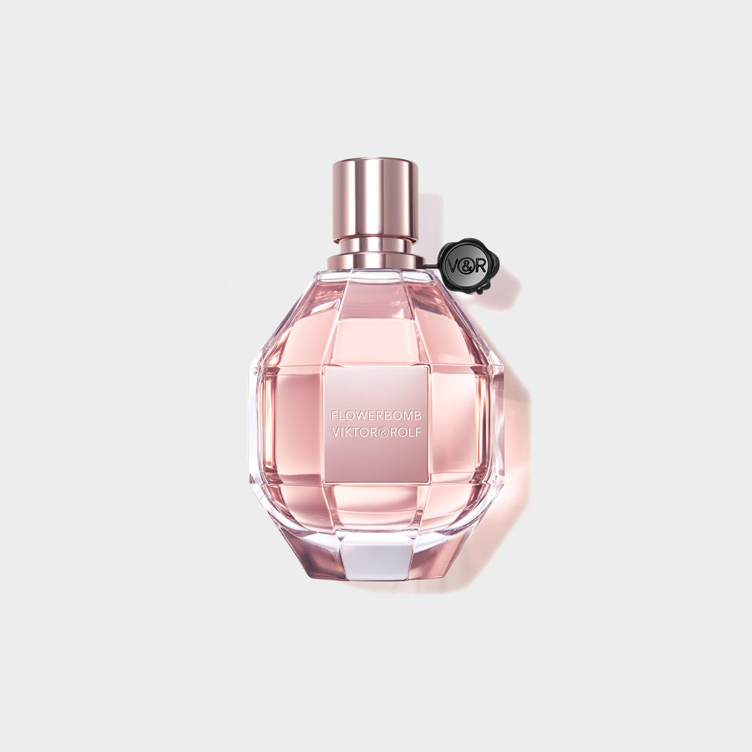 A feminine, diamond-cut glass bottle of Flowerbomb by Viktor & Rolf, featuring a blush pink fragrance for women with floral notes.