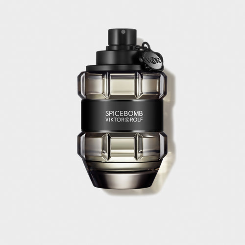 Elegant grenade-shaped bottle of Viktor & Rolf Spicebomb fragrance with a sleek black cap and label on a beige backdrop.