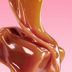 Melted caramel or chocolate in a wavy pattern on a pink background